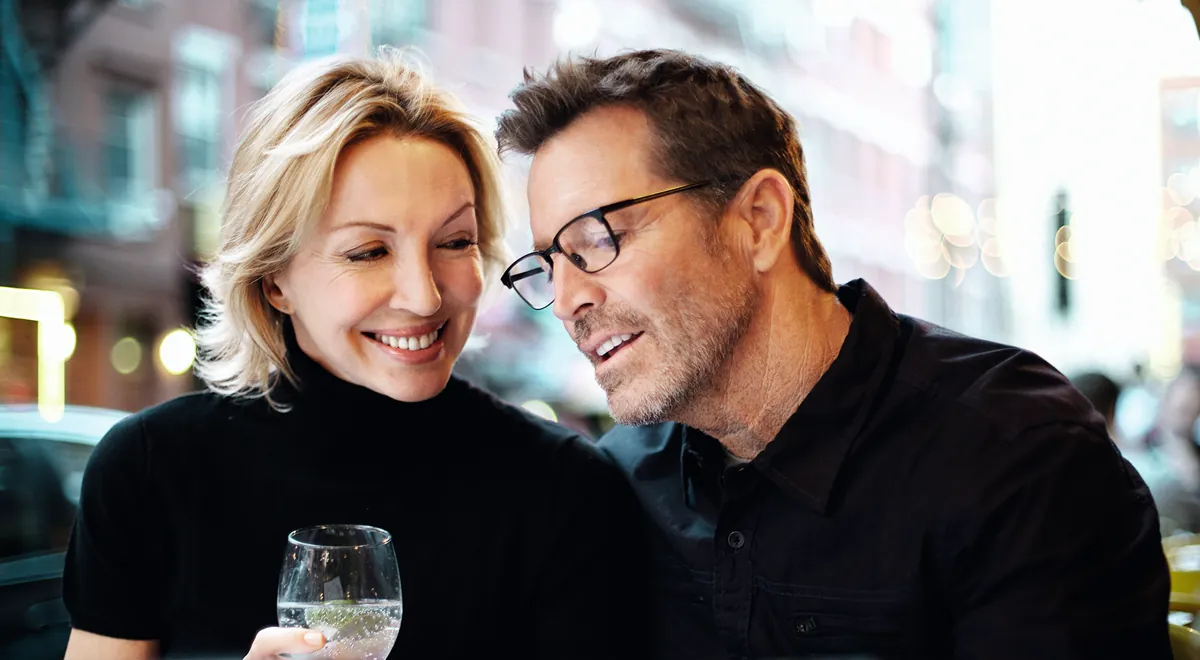 A couple talking at a busy cafe, from Phonak's Lyric campaign.
