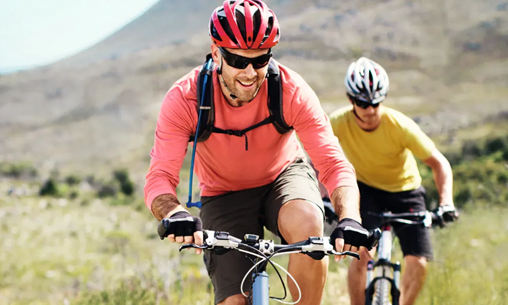 Two people mountain biking, from Phonak's Lyric campaign.